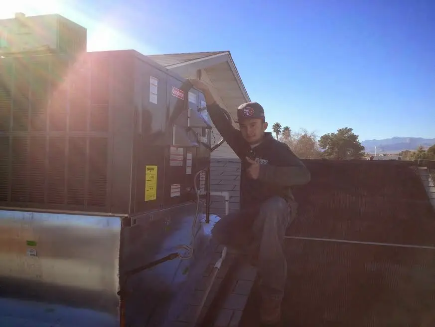 HVAC technician performing Air Duct Repair on a rooftop unit in Zeeland