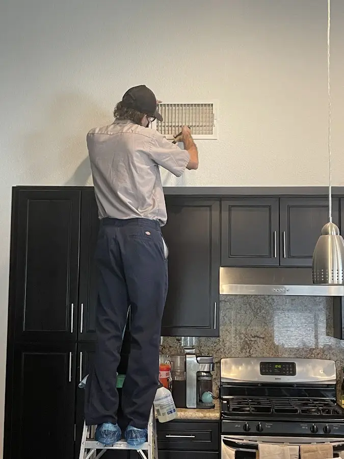 Technician inspecting an air vent during HVAC service in Zeeland